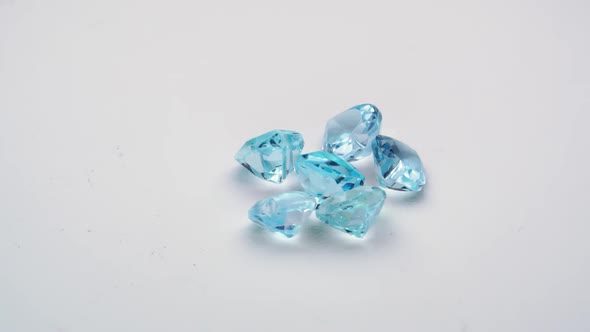 Natural Blue Topaz Gemstones on the White Background Turning Table