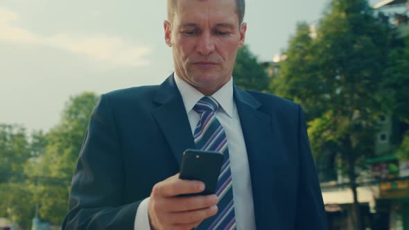Male Reading Phone Message or Downloading an App for His Mobile Phone