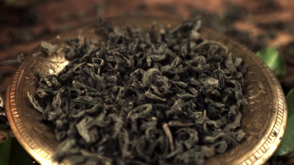 Super Slow Motion on the Plate Fall Dry Leaves of Fragrant Tea