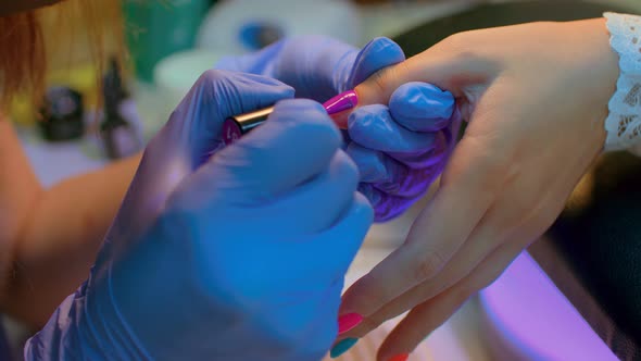 Master of Manicure Getting Professional Manicure in Beauty Salon Woman Puts Nail Polish