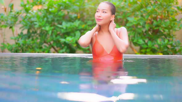 Young asian woman enjoy around outdoor swimming pool for leisure