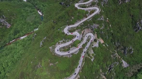 Top shot with drone. Lots of race cars on curvy road in the mountain near Papingo, Greece.