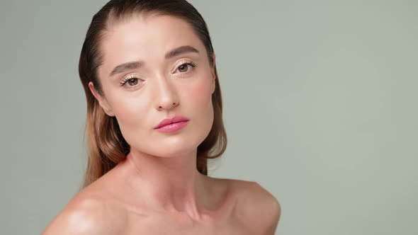 Beautiful Young Woman with Clean Fresh Skin Standing Over Light Grey Background