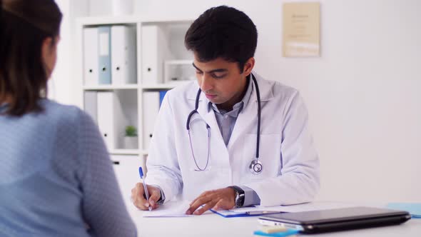 Doctor Writing Prescription for Patient at Clinic