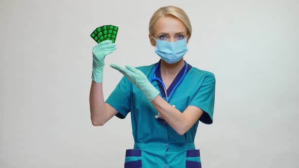 Medical Doctor Nurse Woman Wearing Protective Mask and Rubber or Latex Gloves - Holding Pills