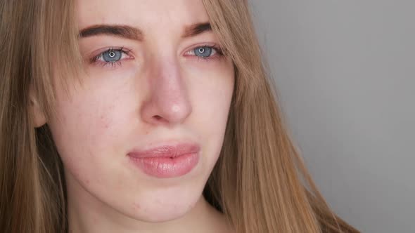 Young Girl with Blue Eyes Without Makeup Posing for the Camera