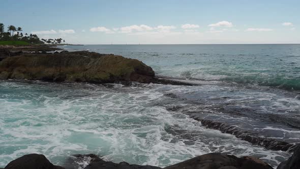 Waves crashing over Oahu's the volcaninc rocks.