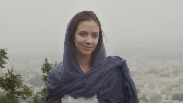 Portrait of Smiling Woman in Blue Shawl Posing on Misty Urban Background Slow Motion. Attractive