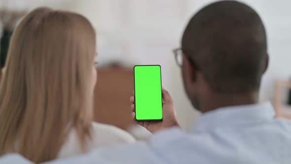 Rear View of Mixed Race Couple Using Smartphone with Green Chroma Key Screen