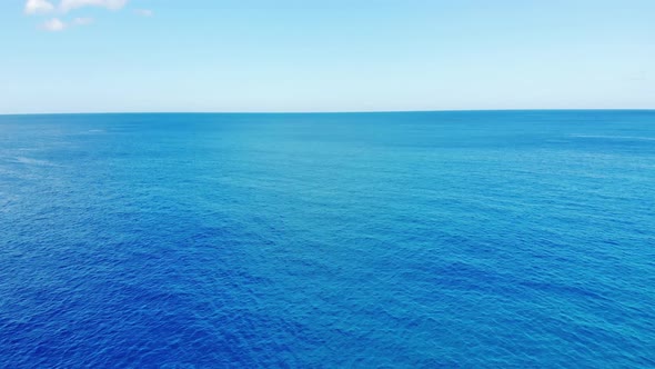 Camera flies over the blur ocean waves to  the clean horizon 