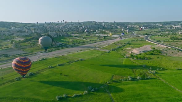 4K Aerial view of Goreme. Colorful hot air balloons fly over the valleys.