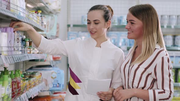 Pharmacist and Woman Choosing Medicine Near Trade Shelf