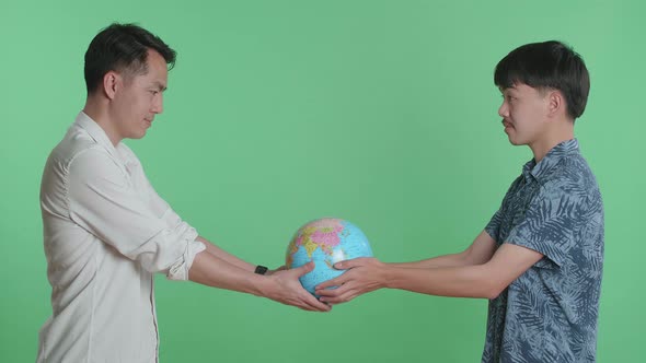 young Asian Man Hand In The World Globe To Adult Man In Green Screen Background