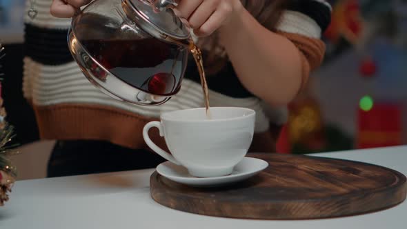 Close Up of Pouring Beverage From Tea Kettle at Festive Home