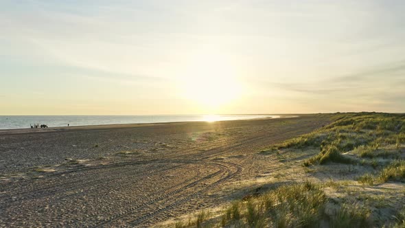 Wide Shot of the Ocean Coast and Beach with Calm Sea Waters During Sunrise