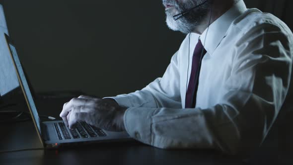 Cropped Shorn of Businessman in Headset Using Laptop