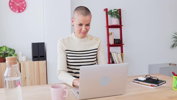 Smiling Mid Adult Woman Using Laptop at Home Office