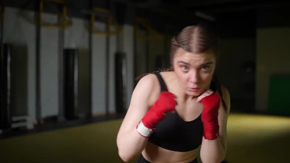 Female Fighter Trains His Punches Training in the Boxing Gym Young Woman Looks at the Camera and