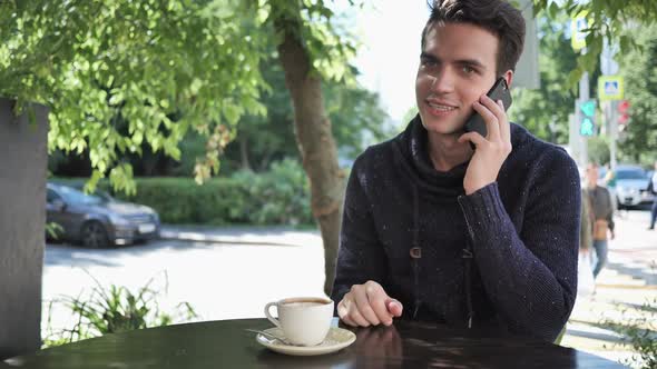 Young Man Talking on Phone Negotiating in Good Mood