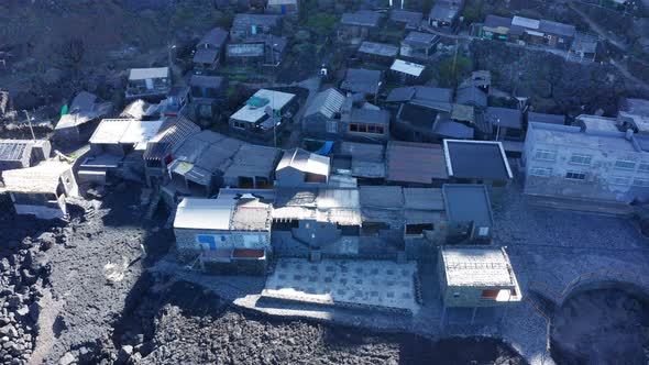 Aerial tilt down and lift up over fishing village Pozo de Las Calcosas