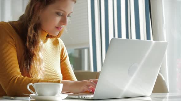 Beautiful Sunny Day Young Woman Drinks Morning Coffee in a Cafe, Making Online a Purchase Easy
