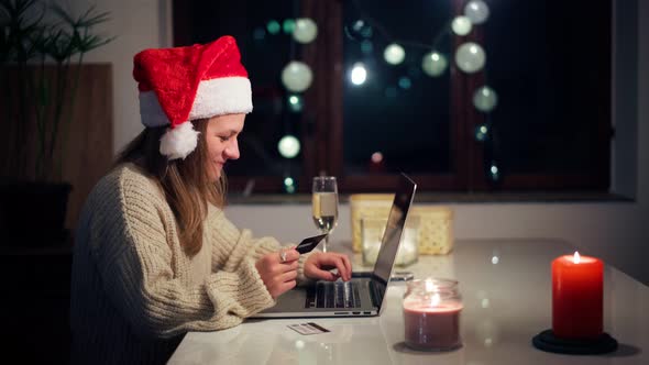 A Woman in a Christmas Hat Makes Purchases on the Internet