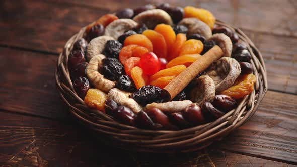 Mix of Dried Fruits in a Small Wicker Basket on Wooden Table