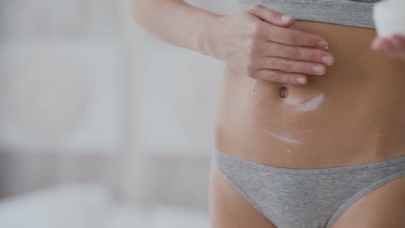 Woman Applying Moisturizer Cream on Her Belly