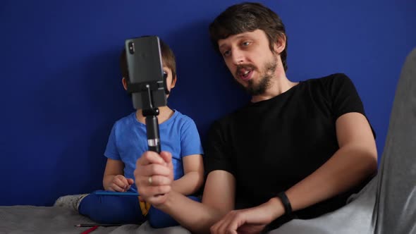 Dad and Son Talk on the Phone with Relatives Video with a Monopod