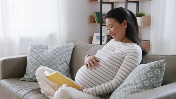 Happy Pregnant Woman Reading Book at Home