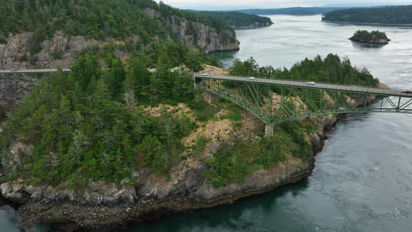 Wide aerial shot pulling away to reveal the magnitude of the Deception Pass bridge.