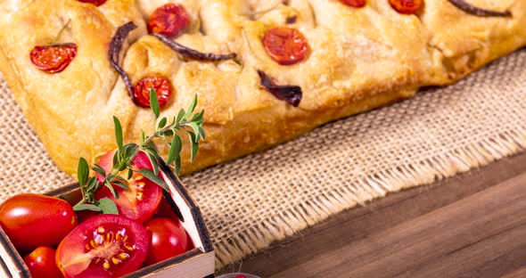 Traditional Italian Focaccia with cherry tomatoes, black olives and rosemary.