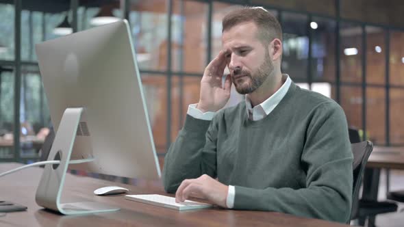 Tired Man Having Headache While Working on Desktop