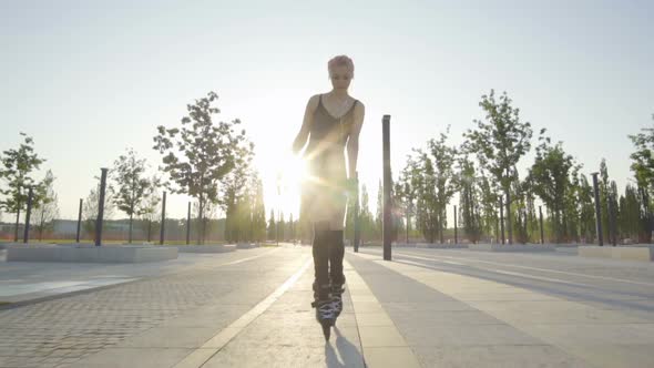 Beautiful Young Woman On Rollerblading In Park At Sunrise