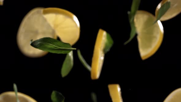 Slow Motion Shot of Flying Mint Leaves and Lemon Slices Collision in the Air