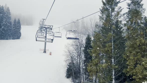 POV Empty Ski Lift Snowy Mountain Winter Forest with Chair Lift At The Ski Resort in Winter