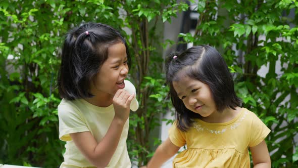Two happy sibling sisters hugging and having fun outdoors in summer, smiling happily together family