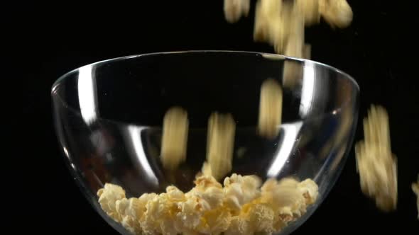 Popcorn Falling in Glass Bowl on Black, Slow Motion
