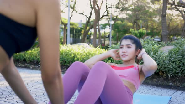 Women Exercising in Park Doing Crunches