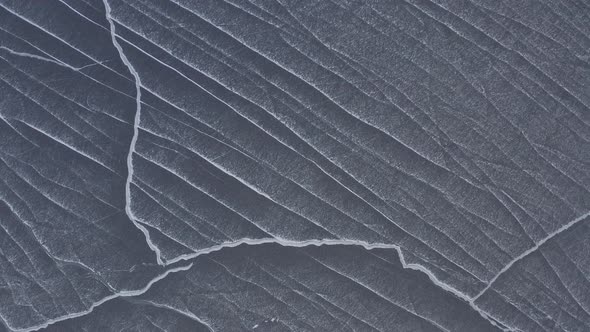 Abstract snow drift lines on lake of ice Ascending aerial view