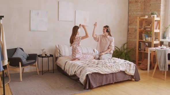 Twin Sisters in Headphones Dancing to Music