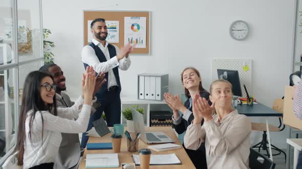Group of Employees Greeting New Worker with Carton Box Clapping Hands and Dancing