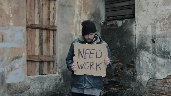 Homeless Holds Piece of Cardboard with Inscription Need Work