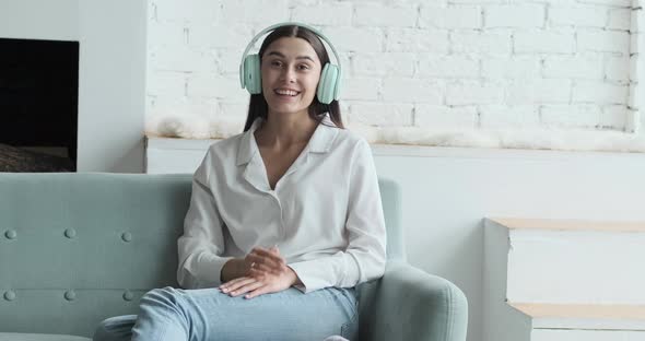 Happy Woman in Headphones Looking at Camera Enjoying Video Meeting with Friends and Colleagues