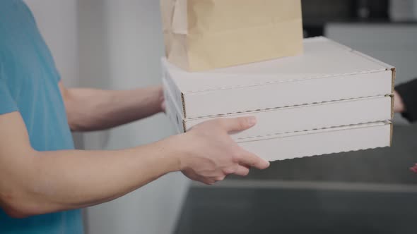 A Food Delivery Man Hands Over the Order to a Woman
