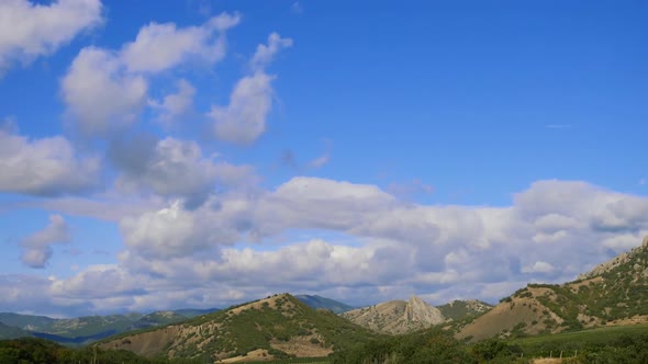 Mountains Against the Blue Sky with White Clouds. Cirrus Clouds Run Across the Blue Sky.