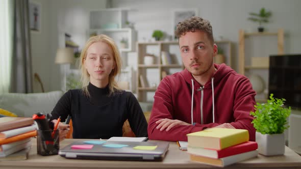 Young Man and Young Woman Together Blogging While Sitting at the Desk at Home in the Living Room