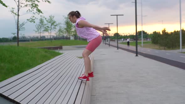 Sportive Young Fit Active Woman Jumping on Bench and Doing Squats in City Park in Summer Morning