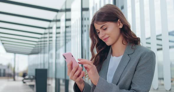 Side View of Attractive Young Woman Scrolling Phone Screen and Making Surprised Facial Expression