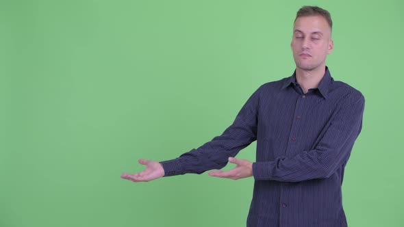 Stressed Businessman Showing Something and Giving Thumbs Down